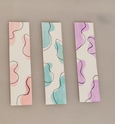 three pieces of paper with different shapes and colors on them, sitting next to each other