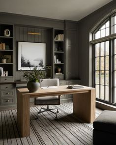 an office with gray walls and wooden floors