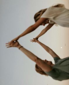 two women are playing with a frisbee in the air