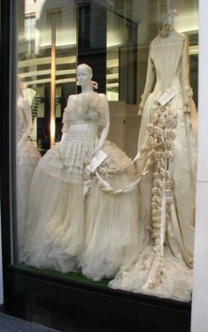 there are many dresses on display in the window