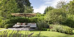 an outdoor living area with couches and umbrellas