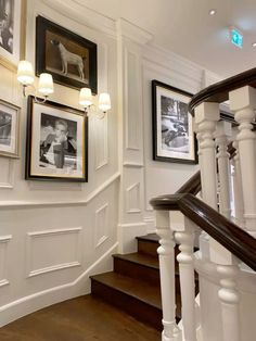 a staircase with pictures on the wall and wood floors