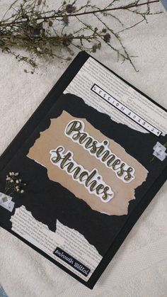 a book sitting on top of a white towel next to a flower pot and plant