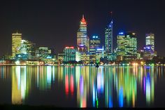 the city lights are reflecting in the water