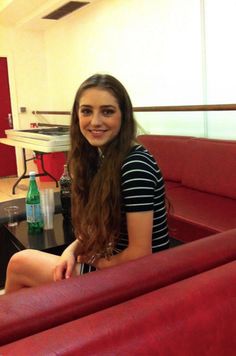 a woman sitting on top of a red couch