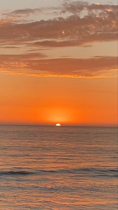 the sun is setting over the ocean with waves