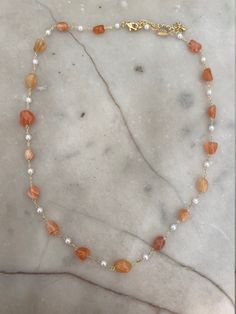 Gold-plated orange agate and pearl beaded necklace. The necklace measures 16 inches with a 2 inch extender. Orange Pearl Necklace, Fall Necklaces, Orange Beaded Necklace, Fall Necklace, Pearl Beaded Necklace, Autumn Necklace, Orange Necklace, Orange Agate, Heart Locket Necklace