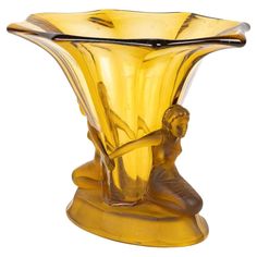 a yellow glass vase with a man sitting on it