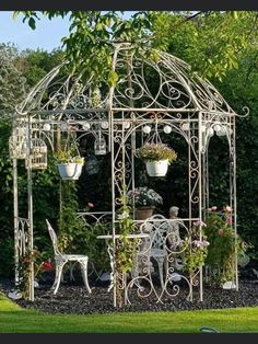 an outdoor gazebo with potted plants and chairs