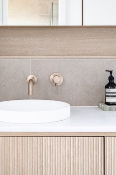 a bathroom sink with two faucets and soap dispenser on the counter