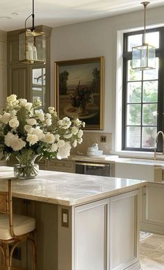 a vase with white flowers sitting on top of a kitchen island