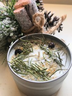 a bowl filled with food sitting on top of a table next to a pine cone