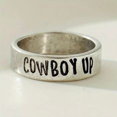 Elevate your style with the Cowboy Up Stamped Ring! This eye-catching piece will make a statement and add a touch of Western flair to your wardrobe. With its unique design, this ring is sure to turn heads and showcase your individuality. Add a touch of personality to your look and show off your love for all things Western with the Cowboy Up Stamped Ring! women’s size 7.5-8 ring Western Rings, Stamped Ring, Cowboy Up, The Cowboy, Ring Women, Stamped Jewelry, Christmas 2024, Makeup Case, Cups And Mugs