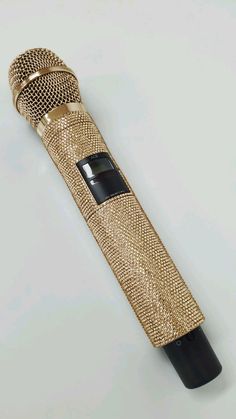 a gold microphone with a black handle on a white background, it looks like something from the movie star trek