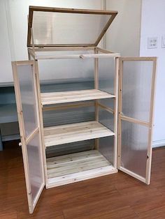 an empty shelf in the corner of a room with wood flooring and white walls