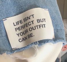 a label on the back of a jean jacket that says, life isn't perfect but your outfit can be