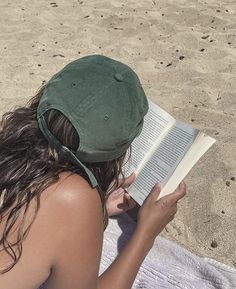 a woman reading a book on the beach