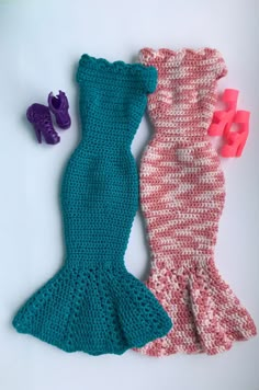 two crocheted mermaid tails next to each other on a white surface with rubber shoes