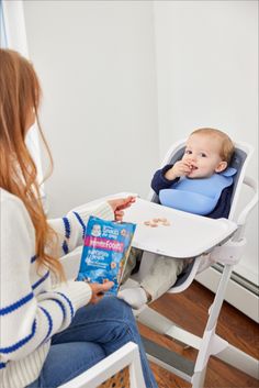 a woman sitting in a high chair holding a book