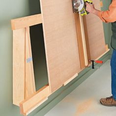 a man using a power tool to attach cabinet doors