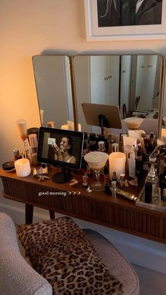 the vanity is full of makeup and personal care items, with candles lit on it