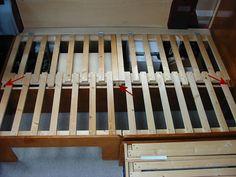 a wooden bed frame with drawers underneath it