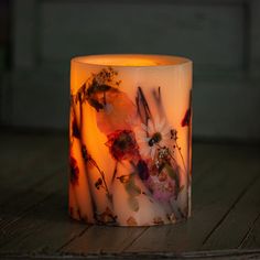 a lit candle sitting on top of a wooden table