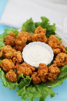 a plate with lettuce and chicken on it, topped with ranch dressing sauce