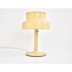 a yellow table lamp sitting on top of a white floor