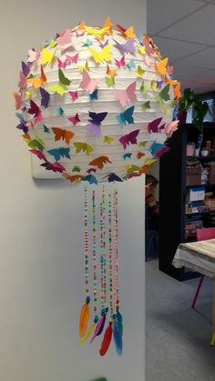 a paper lantern with colorful butterflies hanging from it