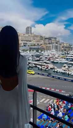 a woman is looking out at the boats in the harbor