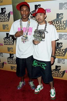 two young men standing next to each other on the red carpet at an awards event