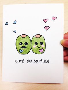 someone is holding up a card with two green apples on it that says olive you so much