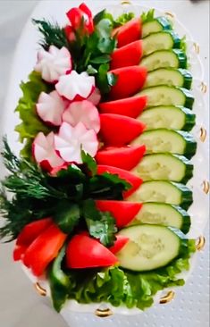 a platter filled with cucumbers, tomatoes and lettuce