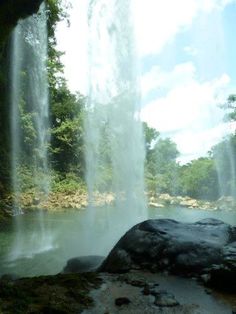 a large waterfall in the middle of a forest