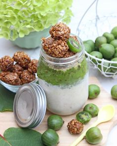 a jar filled with green food next to some leaves