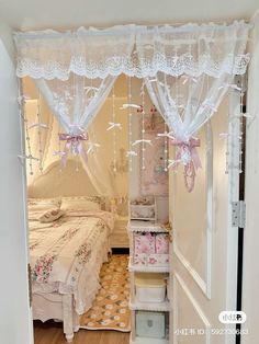 an open door leading to a bedroom with two beds and a closet in it that has pink bows on the curtains