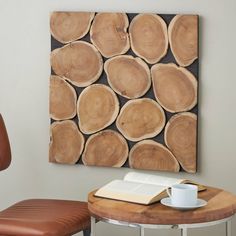 a table with a book and cup on it next to a wooden wall art piece