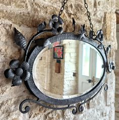 a mirror hanging on the side of a stone wall