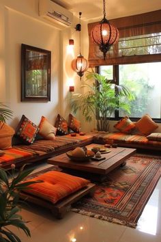 a living room filled with lots of couches and pillows on top of a rug