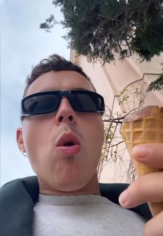 a man in sunglasses eating an ice cream cone