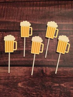 four beer mugs on top of wooden sticks