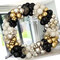 a black, white and gold balloon wreath