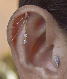 a woman's ear with three different types of piercings