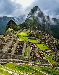 an ancient city surrounded by mountains and clouds