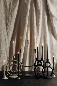 a group of candles sitting on top of a table next to an iron candelabra