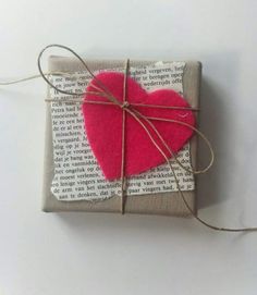 a wrapped gift with a red heart on the front and brown string tied to it