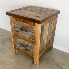 a wooden cabinet with three drawers sitting on the floor next to a white wall and cement floor