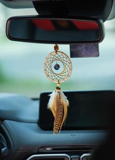 a car dashboard with a dream catcher hanging from the dash