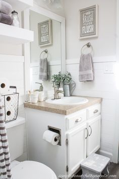 a bathroom with a sink, mirror and toilet paper roll holder on the wall above it